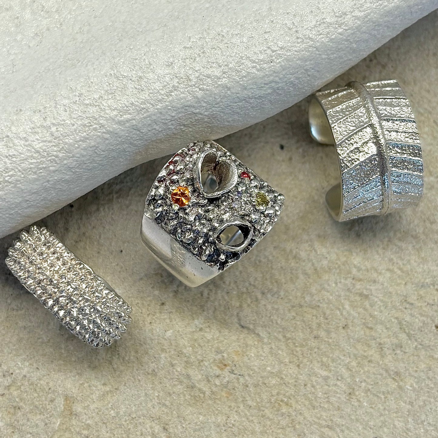 Silver Banksia Rings on a textured surface